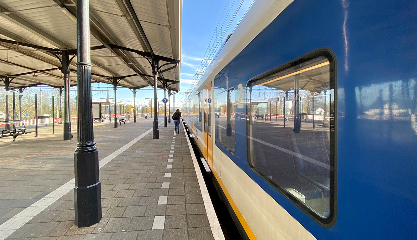 Someone walks to the train at NS station Geldermalsen Someone walks to the train at NS station Geldermalsen