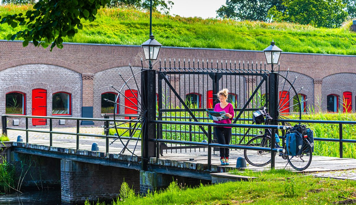 Cyclist looking at a map of the New Dutch Waterline - Fort Voordorp Cyclist looking at a map of the New Dutch Waterline - Fort Voordorp