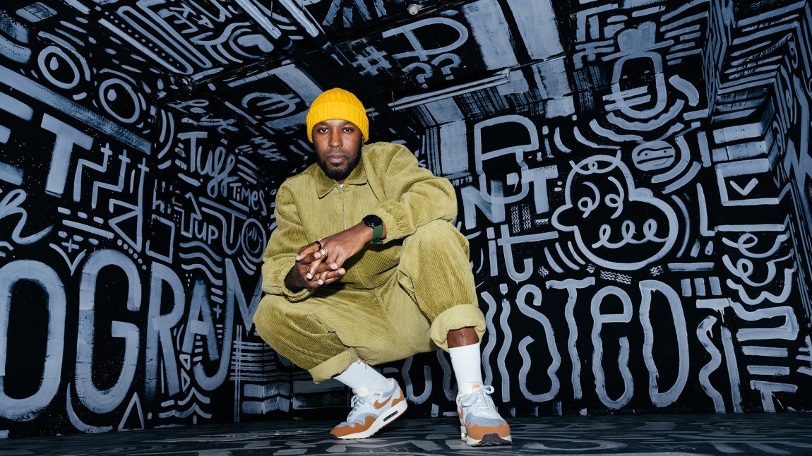 Portraitphoto Elten Kiene squatting on sneakers in front of black and white graffiti Portraitphoto Elten Kiene squatting on sneakers in front of black and white graffiti