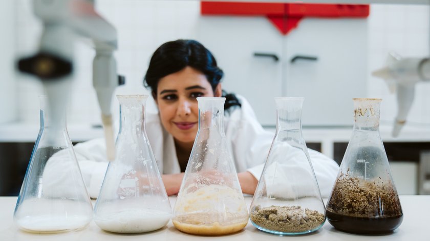 Portraitphoto Jalila Essaidi with 4 glass vases in the lab Portraitphoto Jalila Essaidi with 4 glass vases in the lab