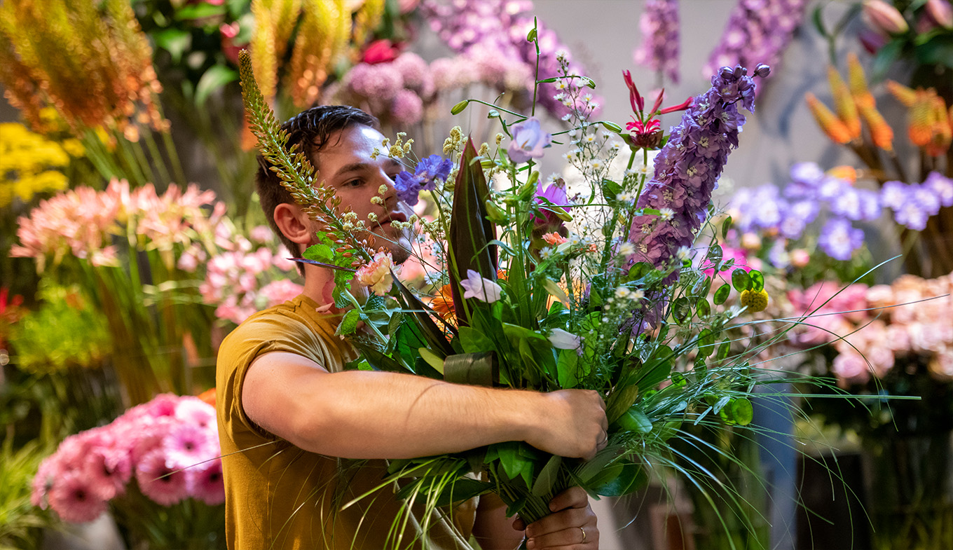 Arranging flowers. Big bunch of flowers in arms. Arranging flowers. Big bunch of flowers in arms.