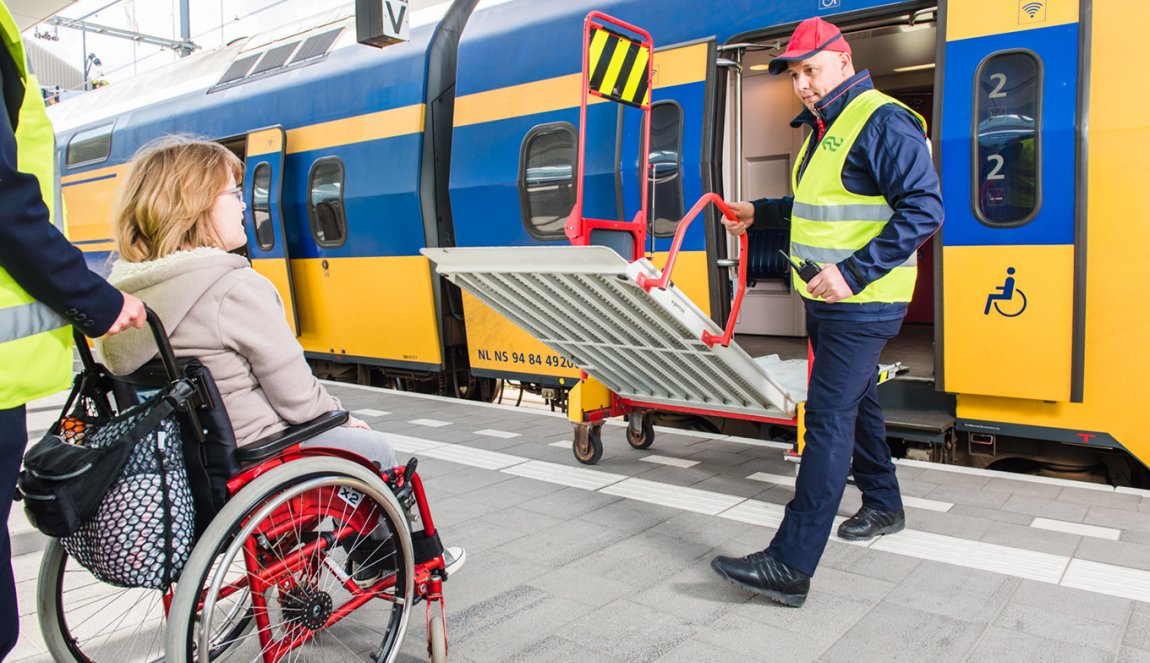 Station assistance; lady in wheelchair gets help to enter train. Station assistance; lady in wheelchair gets help to enter train.