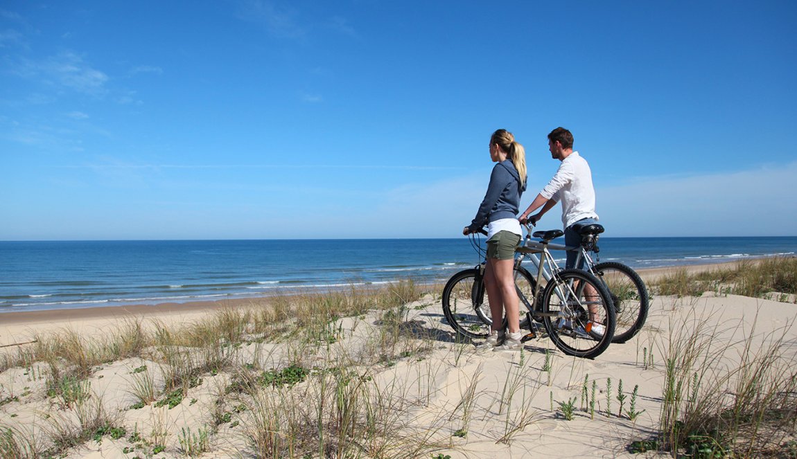 Couple with bikes looking at the ocean Couple with bikes looking at the ocean