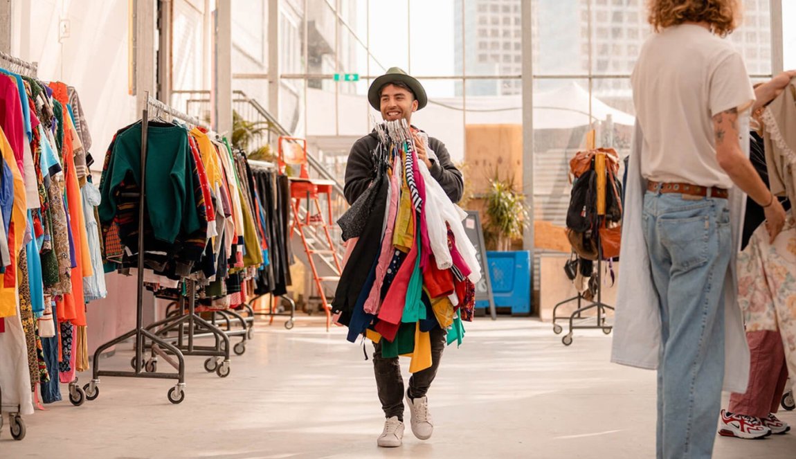 Sustainable shopping per kilo employee with handful of clothes at Kilo Kilo Vintage Sustainable shopping per kilo employee with handful of clothes at Kilo Kilo Vintage