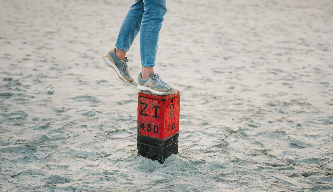 Lady foot on pole in sand on beach in Schiermonnikoog Friesland Lady foot on pole in sand on beach in Schiermonnikoog Friesland
